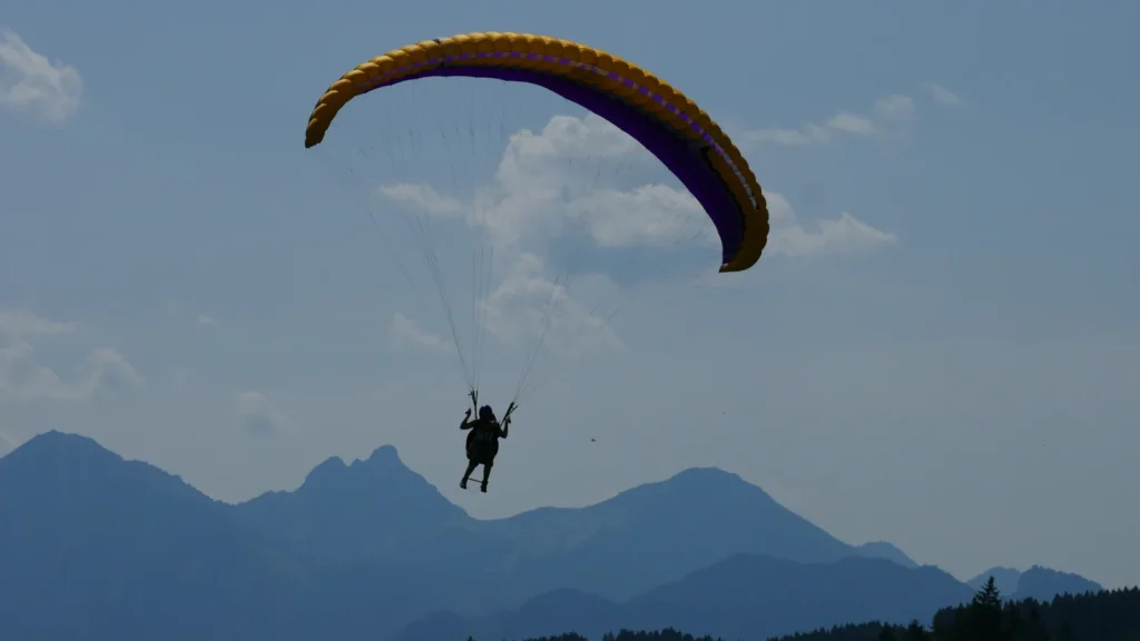 Anja Winter fliegt Gleitschirm vor Bergkulisse